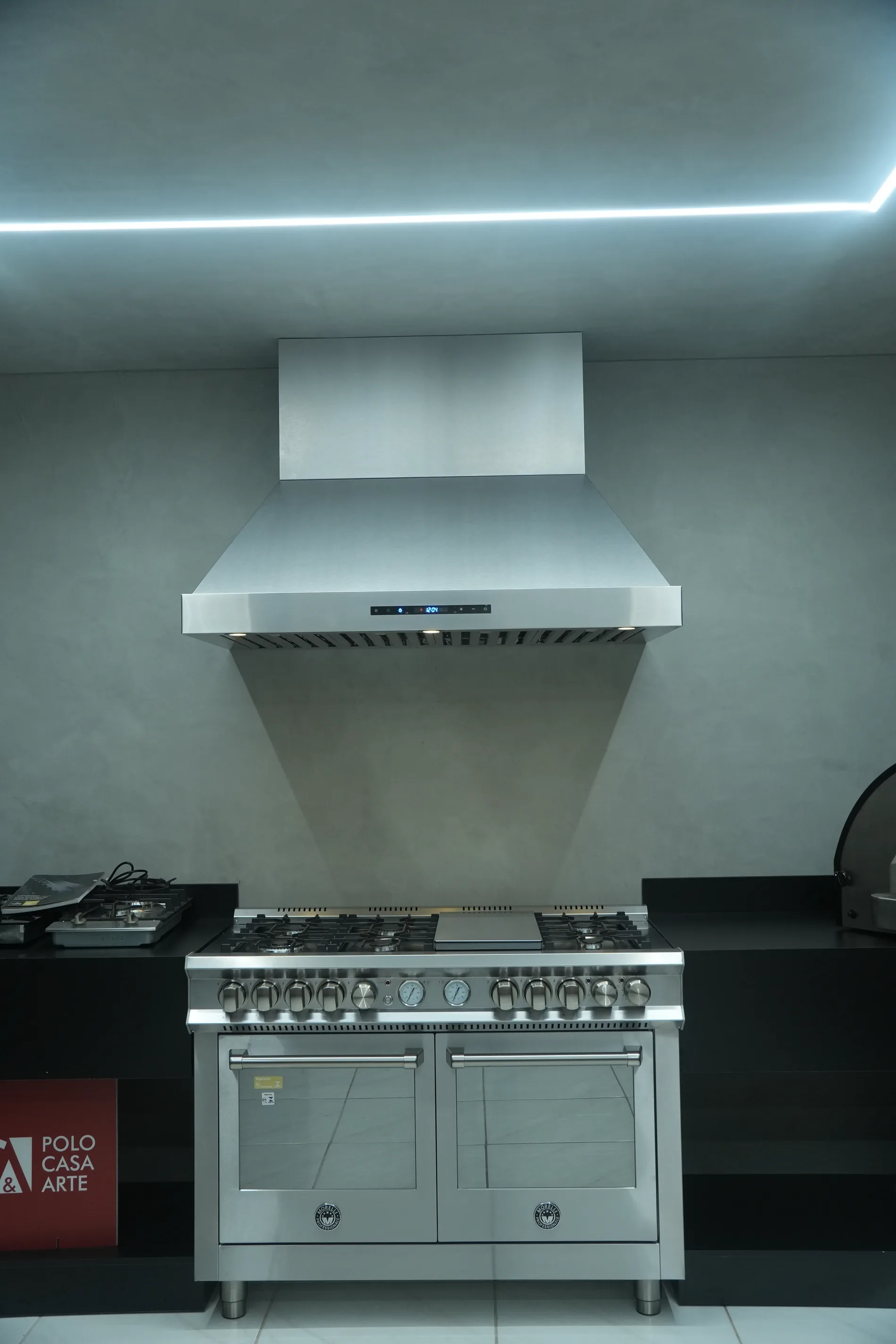 Coifa Máxima Domus de parede em inox, instalada sobre fogão de piso