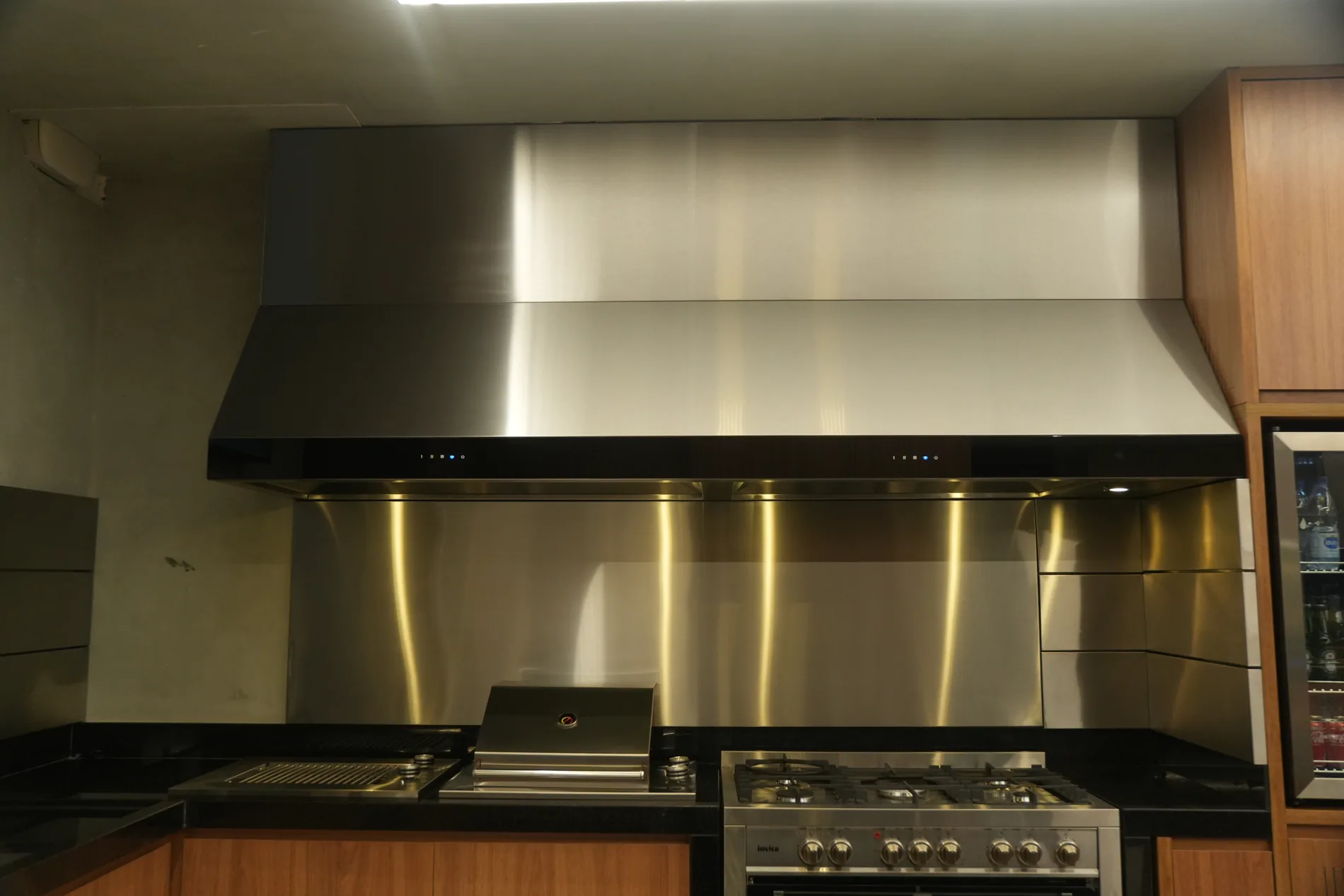 Coifa Máxima Gourmet conjugada em inox, sobre fogão e grill da área gourmet