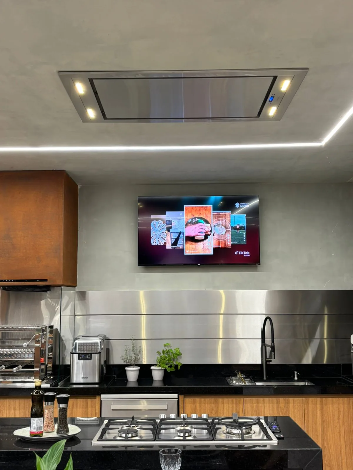 Ambiente com a coifa Máxima Zenith embutida no teto sobre o cooktop